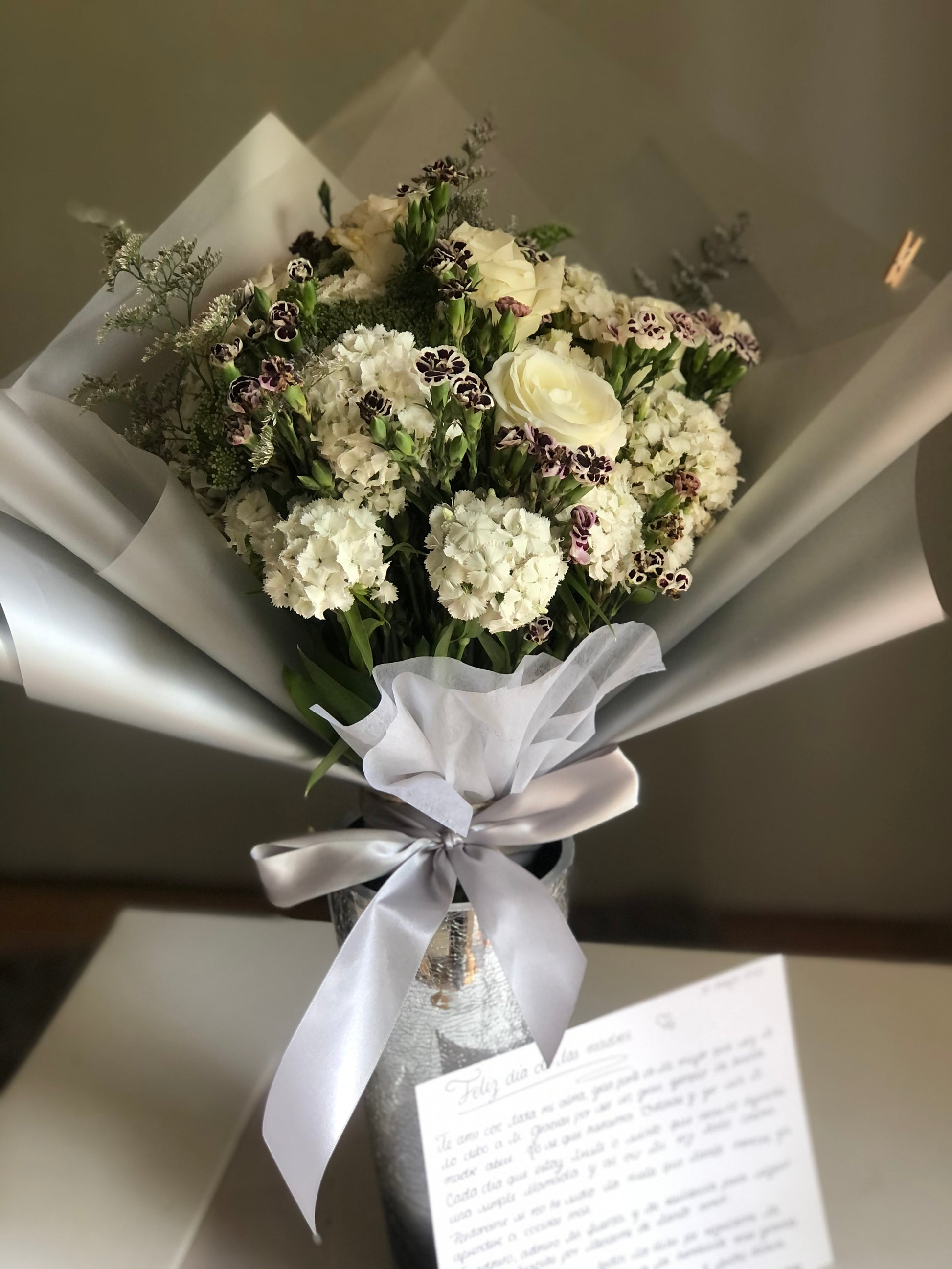 Docena de rosas de invernadero con follaje.