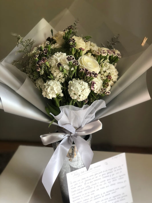 Docena de rosas de invernadero con follaje.