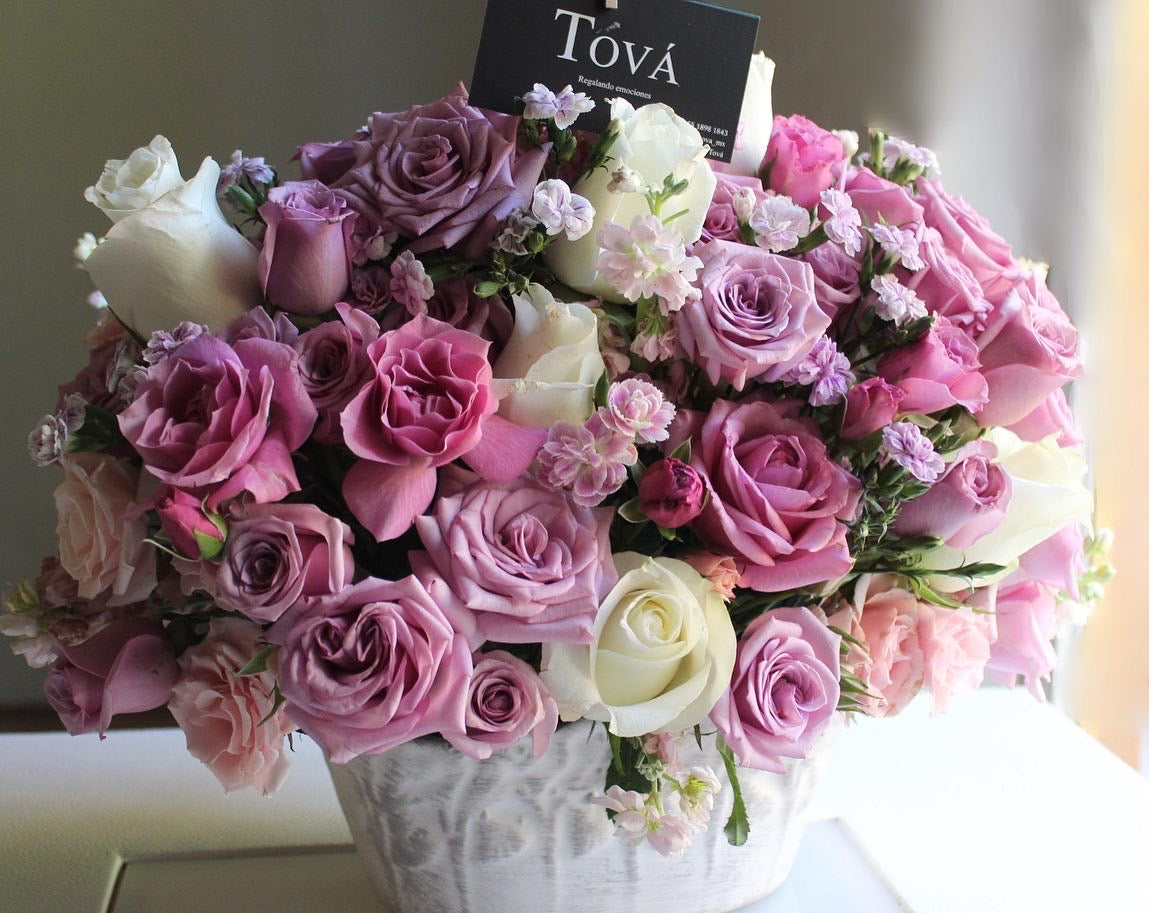 Rosa de invernadero con mini rosa y follaje, sobre base de cerámica.