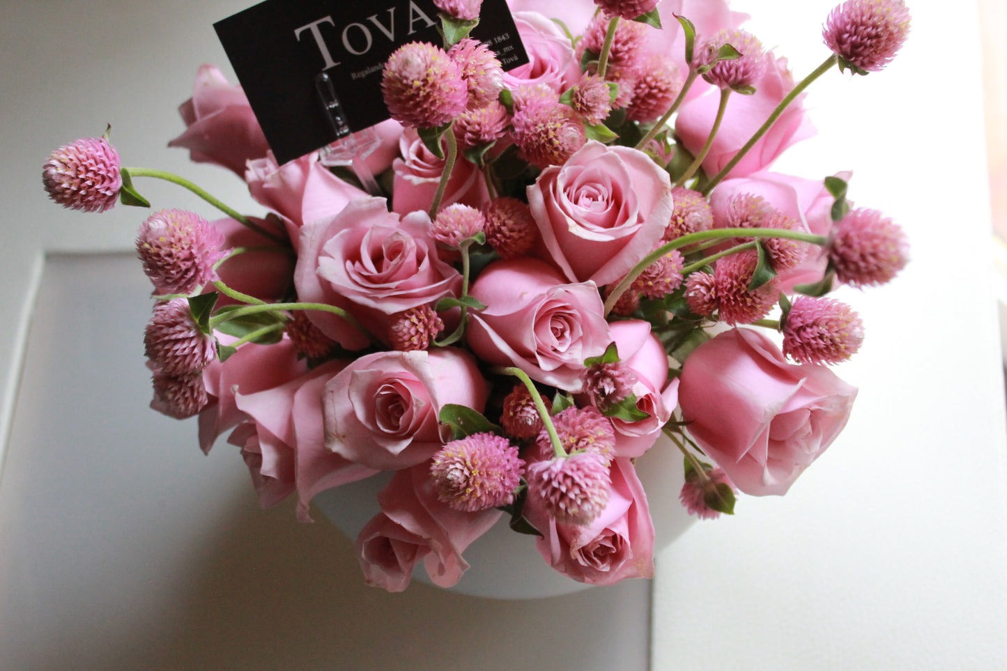 2 docenas de rosas en florero.