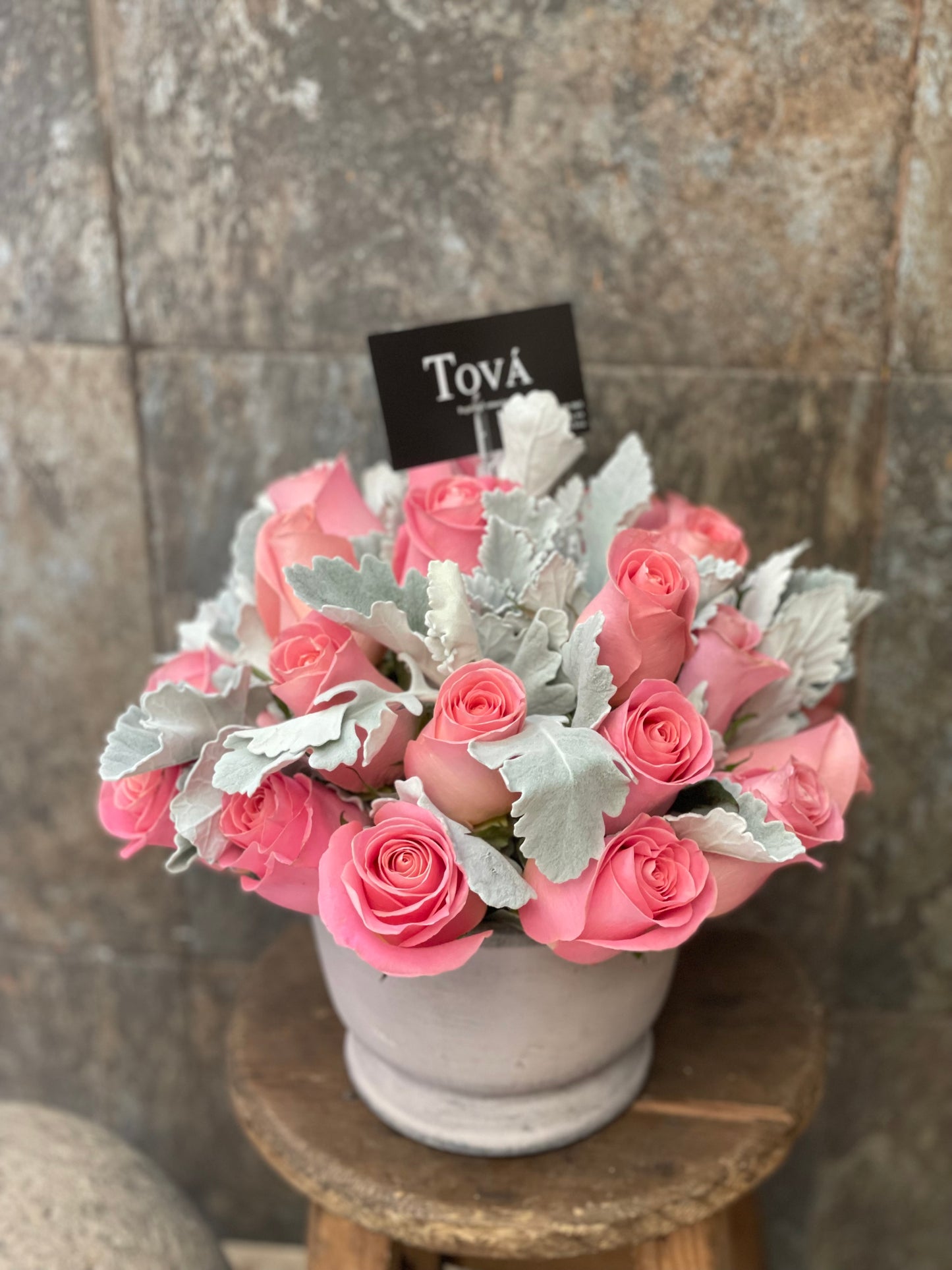 2 docenas de rosas sobre florero de cerámica.