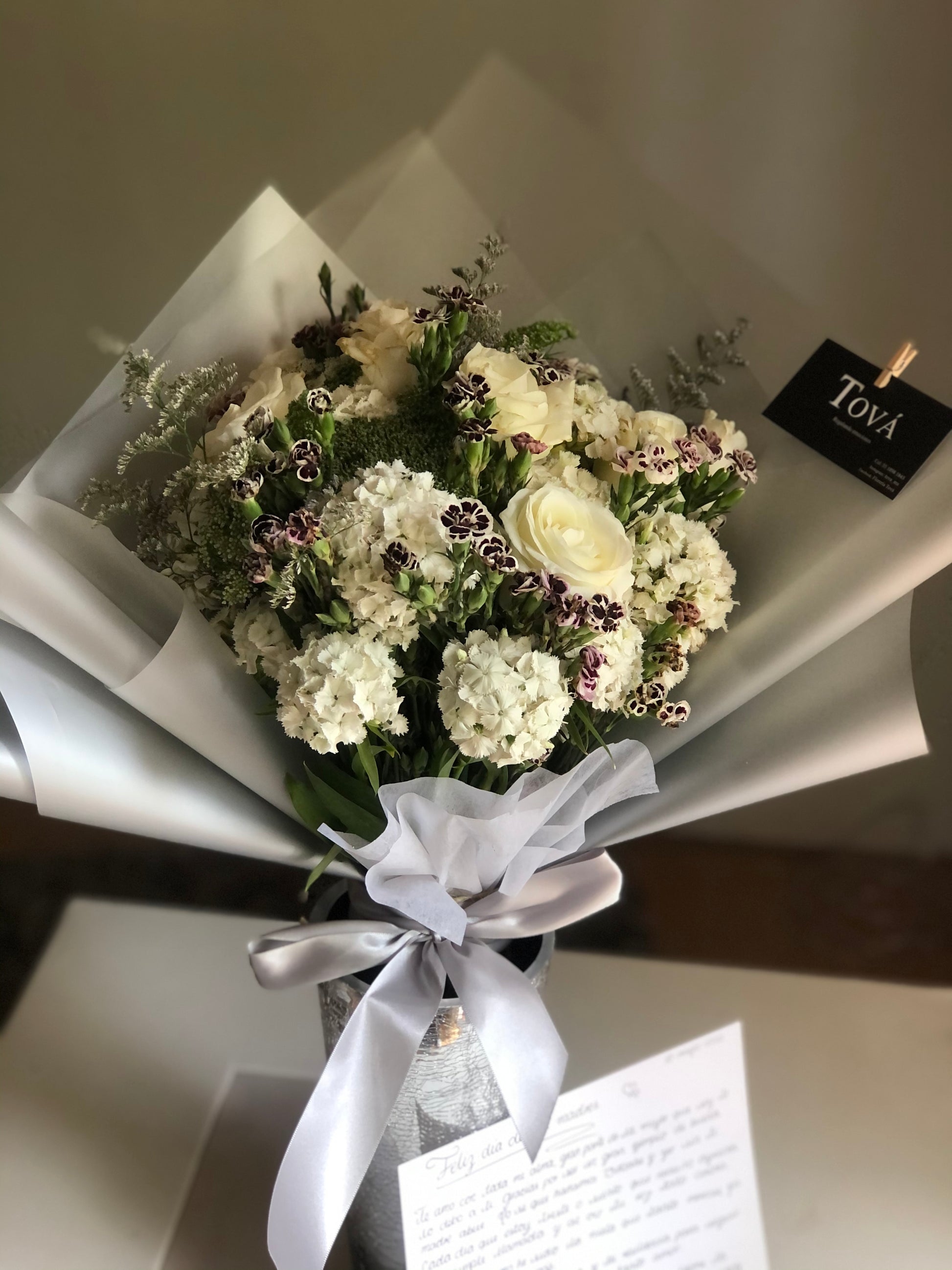 Docena de rosas de invernadero con follaje.