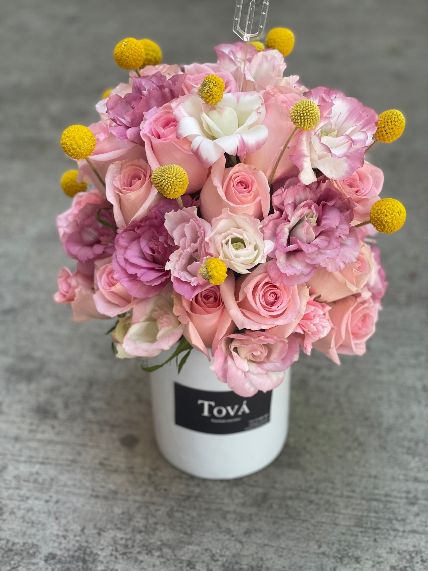 Arreglo de rosas con lisianthus sobre florero de cerámica.