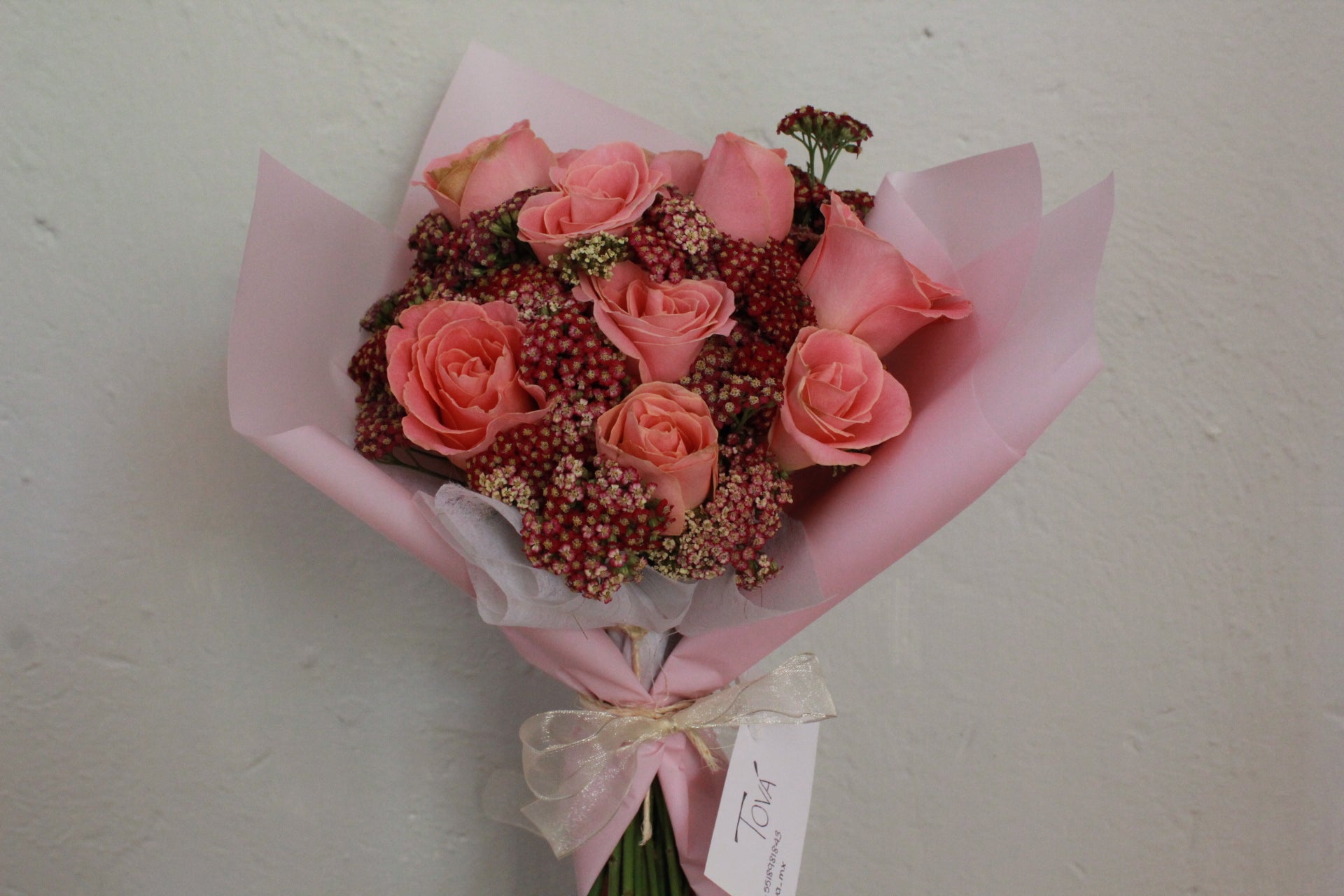 Bouquet de 12 rosas de invernadero con follaje.