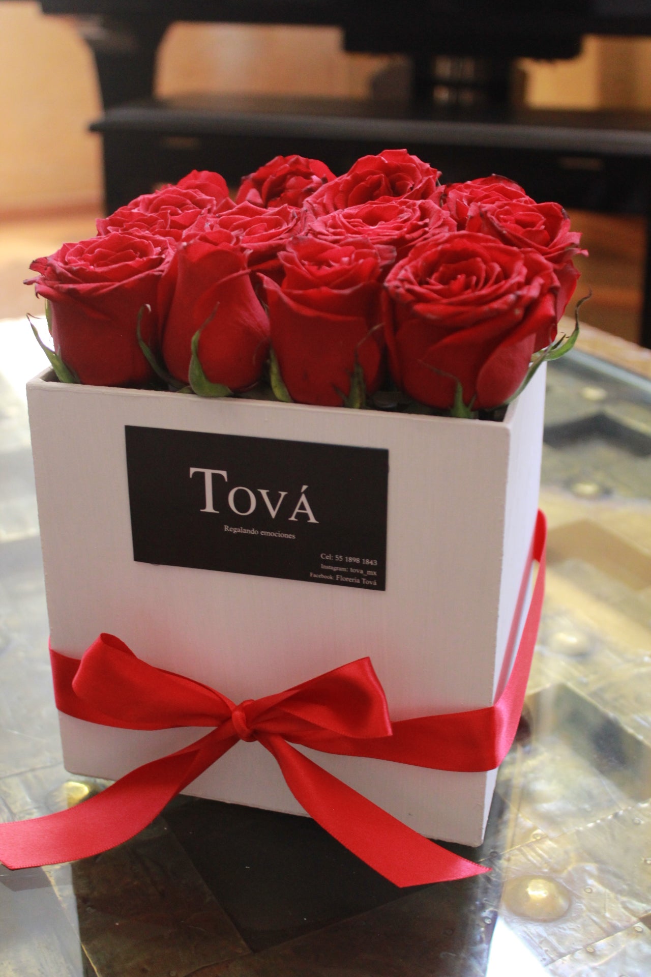 Una docena de rosas sobre caja de cartón rígido.