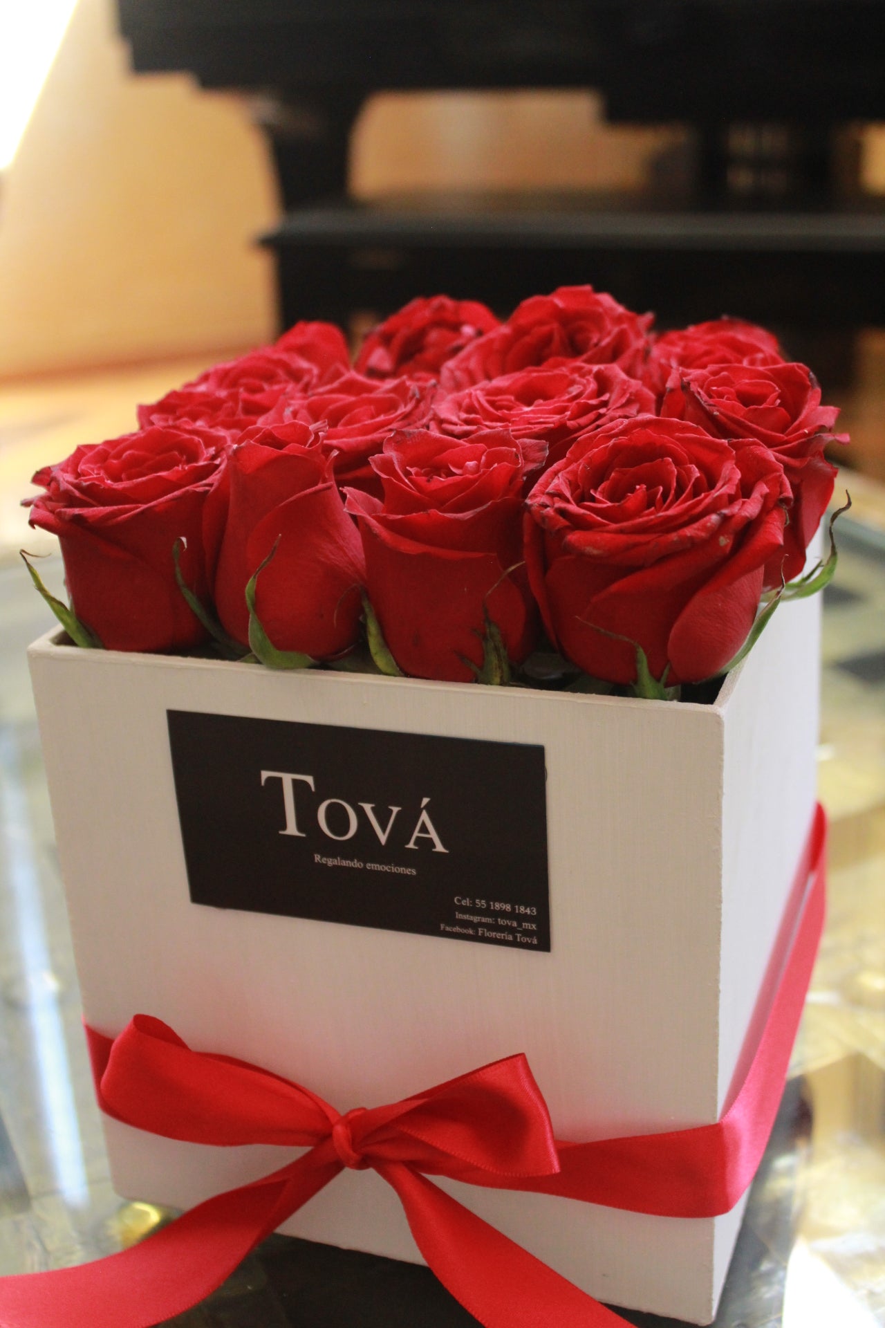 Una docena de rosas sobre caja de cartón rígido.